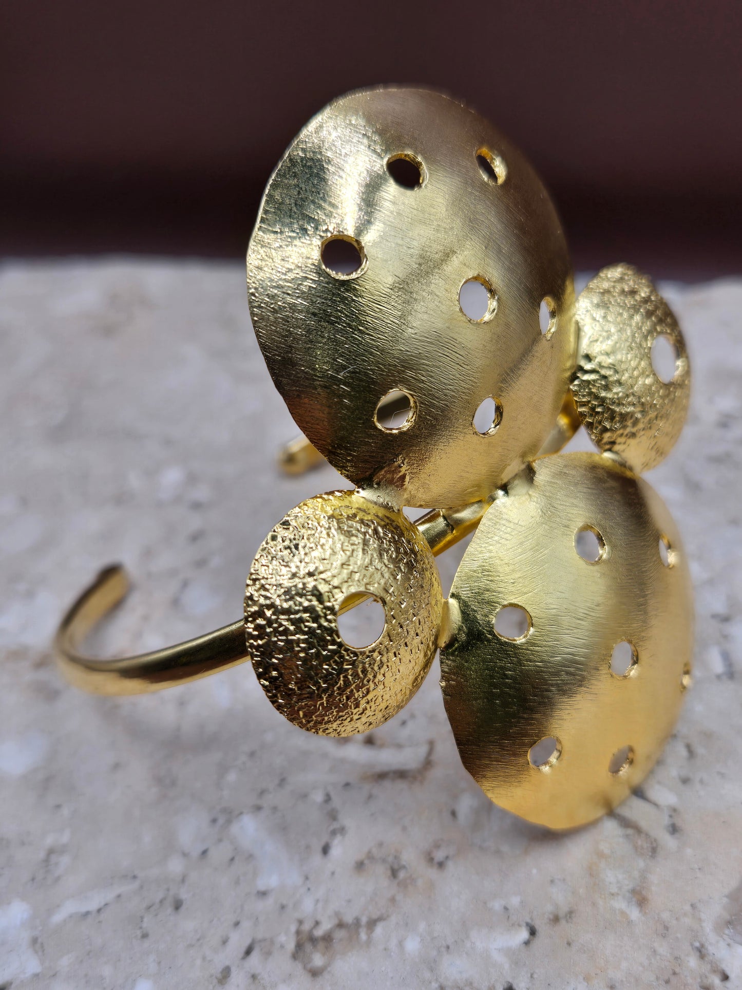 Brazalete círculos perforados, en broce, con baño en oro 24k.