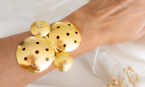 Brazalete círculos perforados, en broce, con baño en oro 24k.