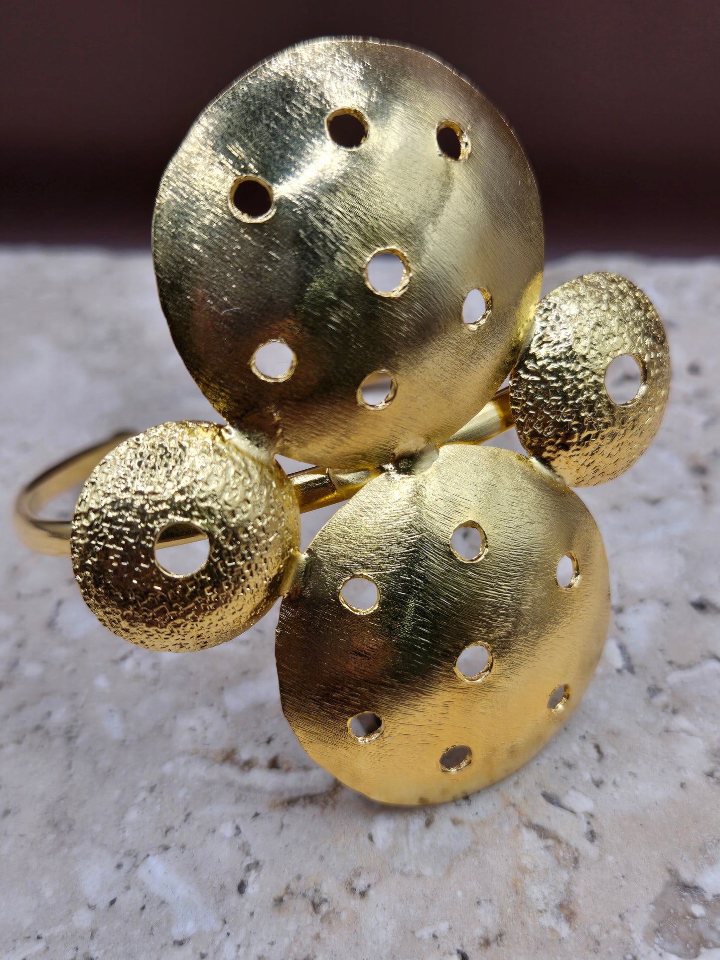 Brazalete círculos perforados, en broce, con baño en oro 24k.